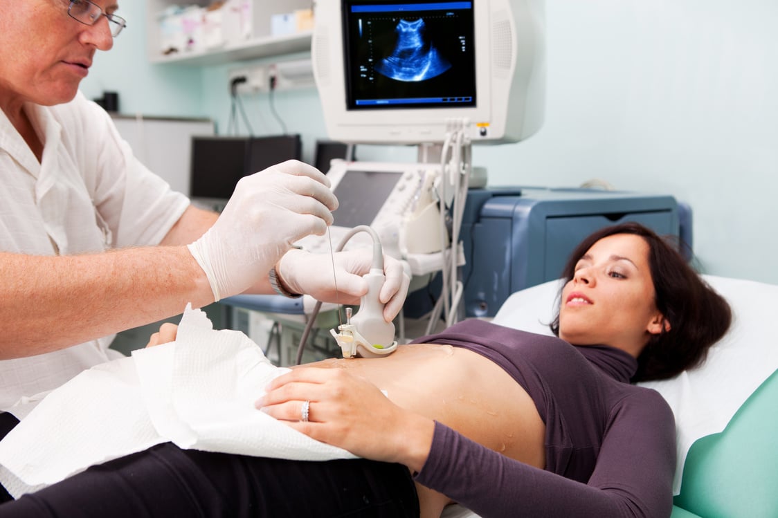 Doctor making liver biopsy to a young women..supporting with Ultrasound